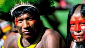 Dois índios nativos sulamericanos de rostos pintados posando para foto.