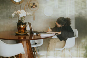 Aluna estudando em casa com ajuda de um laptop.